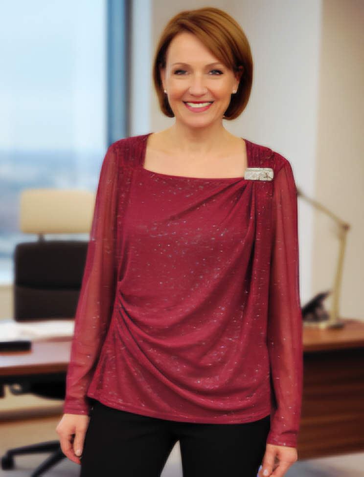 Blusa elegante con mangas transparentes en tela brillante y delicado broche dorado lateral